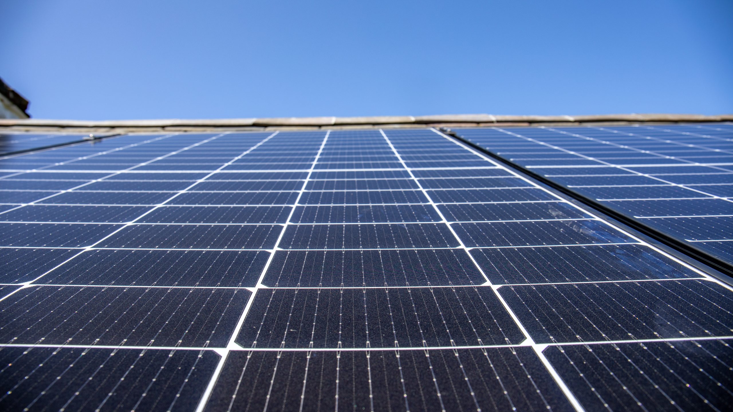 A close up on solar panels with blue sky above